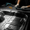 Close-up panel mobil dengan sebagian peredam terpasang, menunjukkan teknik pemasangan peredam mobil.