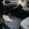 Interior mobil bersih dengan karpet mobil abu-abu yang terawat baik, menunjukkan manfaat karpet mobil dalam menjaga kebersihan dan estetika kabin.