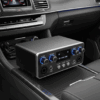 Preamp karaoke mobil dengan kontrol volume mikrofon dan musik, serta lampu indikator biru, terpasang di konsol mobil.